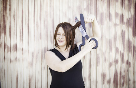 Girl cutting her hair with scissors toy funの写真素材