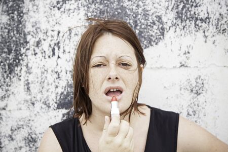 Girl painting her lips bright red, fashion and beautyの写真素材