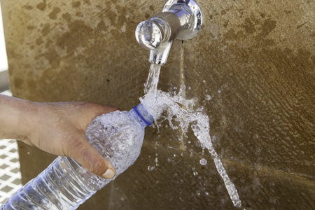 Filling water bottle in fountain, refresh and thirsty