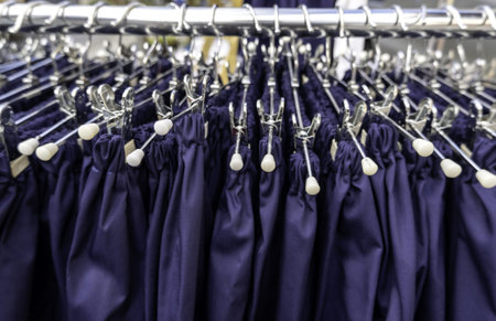 Detail of a coat rack with metal hangers and clothes in a marketの写真素材