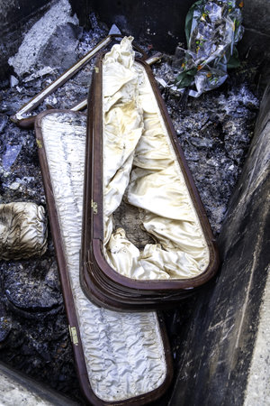 Burnt coffin wit0h flowers in cemetery, religion and burialの写真素材