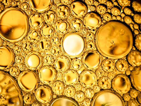 gold yellow beer oil organic abstract texture pattern bubbles macroの写真素材