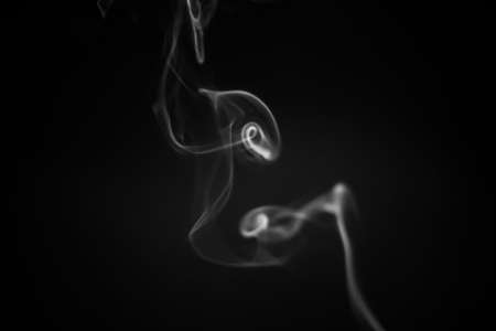 Abstract colorful smoke on black background simultaneously creating figures in the airの写真素材