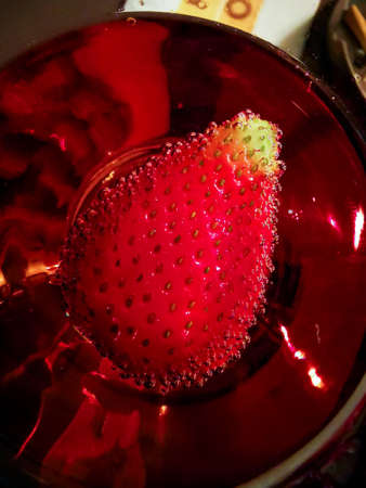 pink rose wine with sparkled strawberries in it macroの写真素材