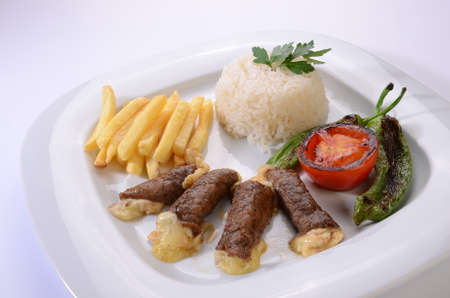 rolled beef steaks filled with cheese with salad and french friesの写真素材