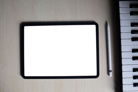 pro tablet for artist with pencil flat lay top view with midi keyboard and synthesizerの写真素材