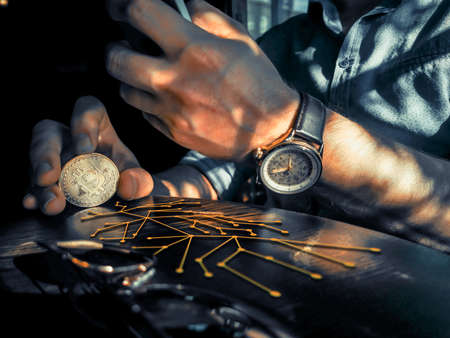 bitcoin holding rich male using his phone for remote exchange e-commerce e-business on the pub tableの写真素材