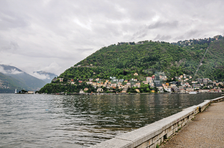 Walking on Lake of Como and buildings in a cloudy rainy day. Near the city of Como, a pleasant town a few miles from Milan. Located in the Lombardy region, northern Italyの写真素材