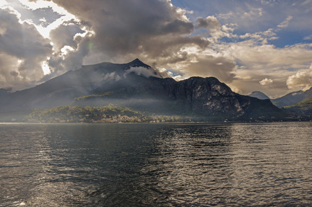 View of Lake Como in a cloudy day with sunshine in Bellagio, a charming tourist village between the lake and the mountains of the Alps. Located in the Lombardy region, northern Italyの写真素材