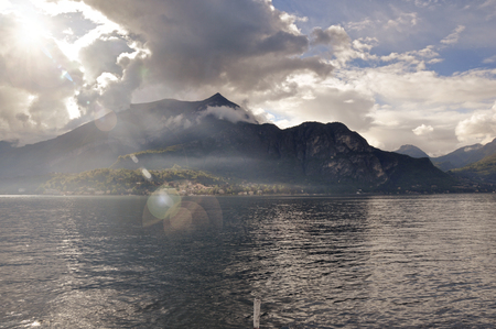 View of Lake Como on a cloudy day with sunshine in Bellagio, a charming tourist village between the lake and the mountains of the Alps. Located in the Lombardy region, northern Italy. Retouched photoの写真素材