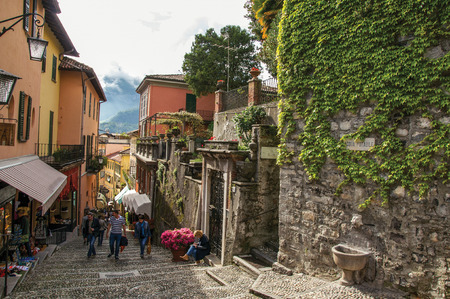 Como, Italy - May 06, 2013. View of alley in hillside, buildings and wall with bindweed in Bellagio, a charming village between the lake and the mountains of Alps. Lombardy region, northern Italyのeditorial素材