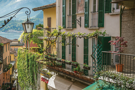 Como, Italy - May 06, 2013. View of Como Lake, balconies with open blinds and bindweed in Bellagio, a charming village between the lake and the mountains of Alps. Lombardy region, northern Italyのeditorial素材