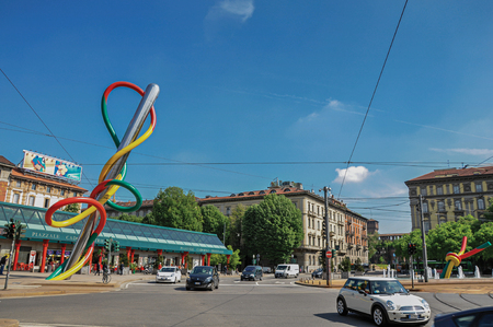 Milan, Italy - May 07, 2013. Street view with cars, colorful modern sculpture and sunny sky, at the city center of Milan, large and modern city. Located in the Lombardy region, northern Italyのeditorial素材