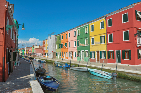 Panoramic view of colorful buildings and boats in front of the canal, in a sunny day at Burano, a gracious little town full of canals, near Venice. Located in the Veneto region, northern Italyの写真素材