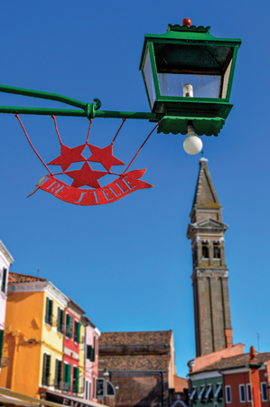 Burano, Italy - May 08, 2013. Detail of restaurant logo made in iron and lamp on a sunny day in Burano, a gracious little town full of canals, near Venice. Located in the Veneto region, northern Italyのeditorial素材