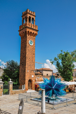 Murano, Italy - May 08, 2013. View of clock tower made of bricks and a star shaped glass sculpture at Murano, a little town on top of islands near Venice. Located in the Veneto region, northern Italyのeditorial素材