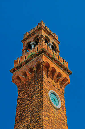 Detail of clock tower made of bricks with sunny blue sky in the background at Murano, a small and pleasant town on top of islands near Venice. Located in Veneto region, northern Italy. Retouched photoのeditorial素材