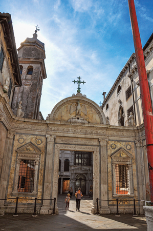 View of church carved portal with people leaving and sun glow. At the city center of Venice, the historic and amazing marine city. Veneto region, northern Italyのeditorial素材