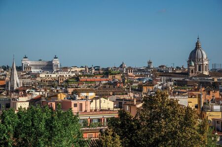 Overview of trees, cathedrals domes and roofs of buildings in the sunset of Rome, the incredible city of the Ancient Era, known as "The Eternal City". Located in the Lazio region, central Italyの写真素材