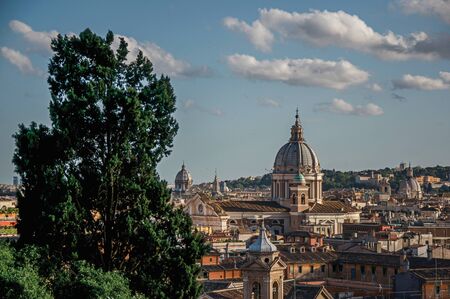 Overview of trees, cathedrals domes and buildings roofs in the sunset of Rome, the incredible city of the Ancient Era, known as "The Eternal City". Located in the Lazio region, central Italyの写真素材