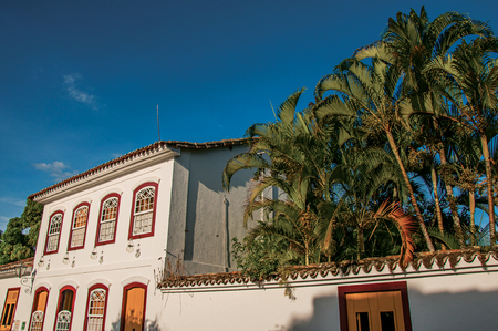 Overview of street with old houses and palm trees at the sunset in Paraty, an amazing and historic town totally preserved in the coast of Rio de Janeiro State, southwestern Brazilの写真素材