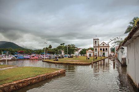 Paraty, Brazil - January 23, 2015. Church and old houses with flooded stone sidewalk and cloudy day in Paraty, a historic town totally preserved in Rio de Janeiro State coast, southwestern Brazilのeditorial素材
