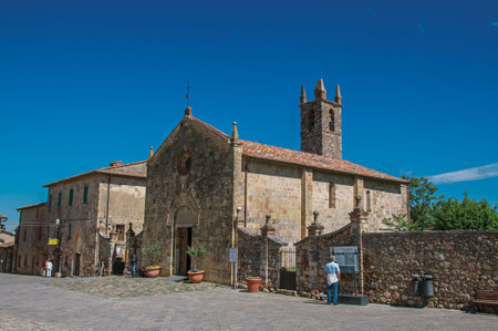 Monteriggioni, Italy - May 13, 2013. People and church at the hamlet of Monteriggioni. A medieval fortress, surrounded by stone walls, at the top of a hill, near Siena. Located in the Tuscany regionのeditorial素材