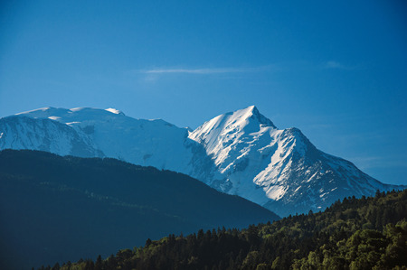 Alpine mountain landscape with forests and blue sky, near Saint-Gervais-Les-Bains. A famous ski resort located in Haute-Savoie Province, near the Mont Blanc in the French Alps.の写真素材