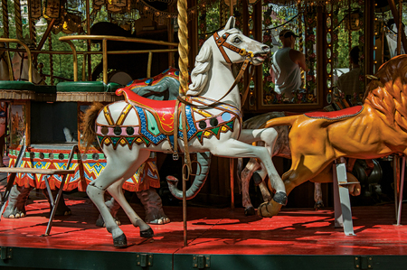 Colorful carousel with white horse in a park of Annecy. An historical and lovely lakeside town located in the department of Haute-Savoie, south-eastern France.の写真素材
