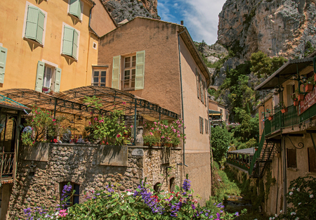 Moustiers-Sainte-Marie, France - July 08, 2016. Restaurant with flowers and cliffs in the lovely village of Moustiers-Sainte-Marie. Provence region, southeastern Franceのeditorial素材