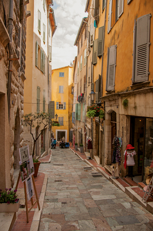 Grasse, France - July 12, 2016. View of narrow street and buildings with shops in Grasse, the friendly town known for producing perfumes. Alpes-Maritimes department, Provence region, southeastern Franceのeditorial素材