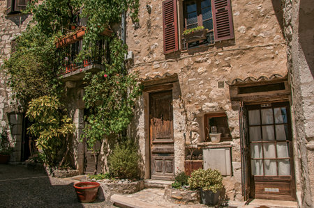 Alley view with wooden doors and plants in Saint-Paul-de-Vence, a lovely well preserved medieval hamlet near Nice. Located in Alpes-Maritimes department, Provence region, southeastern Franceのeditorial素材