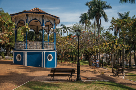 Sao Manuel, southeast Brazil - September 09, 2017. Old colorful gazebo and people amid garden full of trees, in the sunny day at San Manuel. A cute little town in the countryside of São Paulo State.のeditorial素材