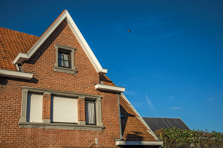 Detail of brick facade and roofs at sunset in the City Center of Tielt. Charming and quiet village in the countryside, near Ghent and surrounded by agricultural fields. Western Belgium.の写真素材