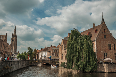 Bruges, Belgium - July 05, 2017. People and old buildings on the canal's edge at Bruges. With many canals and old buildings, this graceful town is a World Heritage Site of Unesco. Northwestern Belgiumのeditorial素材
