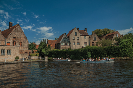 Bruges, Belgium - July 05, 2017. Boat and old buildings on the canal's edge at Bruges. With many canals and old buildings, this graceful town is a World Heritage Site of Unesco. Northwestern Belgium.のeditorial素材