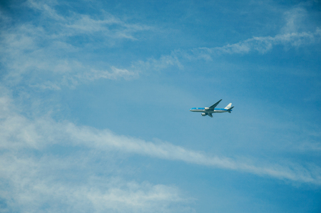 Close up of commercial airplane flying in sunny blue sky at Weesp. Quiet and pleasant village full of canals and green near Amsterdam.のeditorial素材