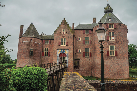 Medieval Ammersoyen Castle with its brick towers, wooden bridge and green garden on cloudy day. Near to the historic and vibrant city of s-Hertogenbosch. Southern Netherlandsのeditorial素材