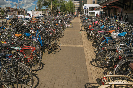 Amsterdam, northern Netherlands - June 26, 2017. Bicycles parked on street in front of the Amsterdam Central Station. The city is famous for its huge cultural activity, graceful canals and bridges.のeditorial素材