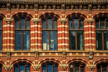 Amsterdam, northern Netherlands - June 26, 2017. Close-up of brick facade with windows and columns in an old building of Amsterdam. Famous for its huge cultural activity, graceful canals and bridges. Retouched photo.のeditorial素材