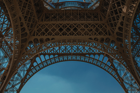 Bottom view of Eiffel Tower made in iron and Art Nouveau style, with sunny blue sky in Paris. Known as the "City of Light", it is one of the most impressive cultural centers in the world. Northern France.の写真素材