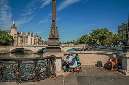 Paris, France - July 08, 2017. Beggar on bridge over the Seine River with sunny blue sky in Paris. Known as the "City of Light", it is one of the most impressive cultural centers in the world. Northern France.のeditorial素材