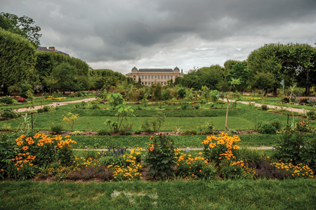 Flowered and grassy yard with building in the background in the Garden of Plants in Paris. Known as the "City of Light", it is one of the most impressive cultural centers in the world. Northern France.のeditorial素材