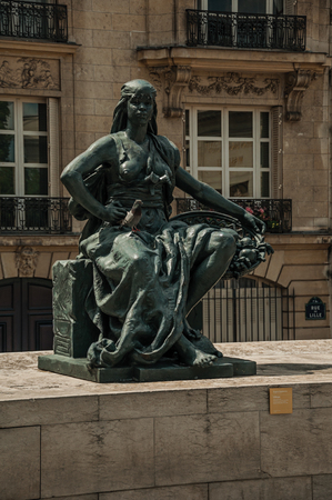 Paris, northern France - July 11, 2017. Statue of woman sitting in front of building in sunny day at Paris. Known as the "City of Light", it is one of the most impressive cultural centers in the world.のeditorial素材