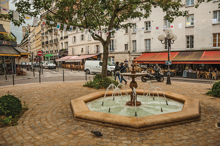 Paris, northern France - July 12, 2017. Small square with fountain, trees and restaurants in the middle of the "Latin Quarter" in Paris. Known as one of the world's most impressive cultural centers.のeditorial素材