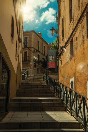 Caceres, Spain - July 03, 2018. Alley with staircase on slope amidst old buildings at Caceres. A cute and charming countryside old village, full of gothic building in western Spain. Retouched photo.のeditorial素材