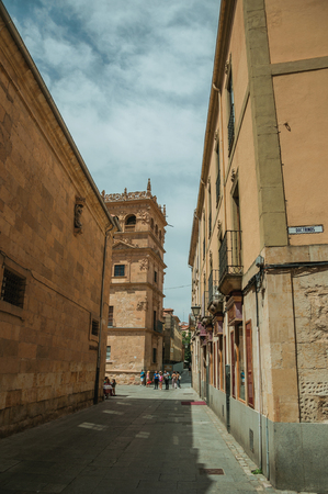 Salamanca, Spain - July 21, 2018. People in a large alley and old gothic buildings made of stone at Salamanca. This lovely medieval town is one of the most important university cities in Spain.のeditorial素材