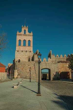 Street going through the Carmen Gateway on the stone city wall and brick tower, in a sunny day at...