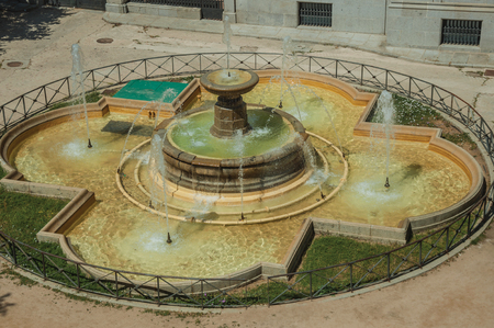 Geometrical fountain with water squirt on a square in front of old building, in a sunny day at Avila. It has the longest and imposing wall completely encircling this well-kept gothic town of Spain.のeditorial素材