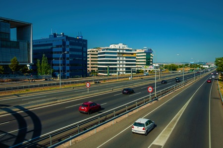 Madrid, Spain - July 23, 2018. Multi lane highway with heavy traffic in a business district in Madrid. Capital of Spain this charming metropolis has vibrant and intense cultural life. Retouched photo.のeditorial素材